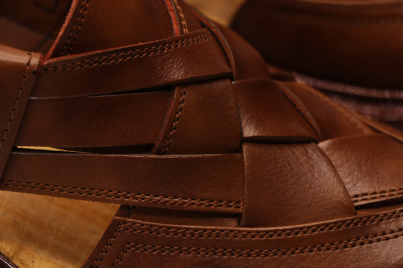 Close-up of a brown woven leather sandal