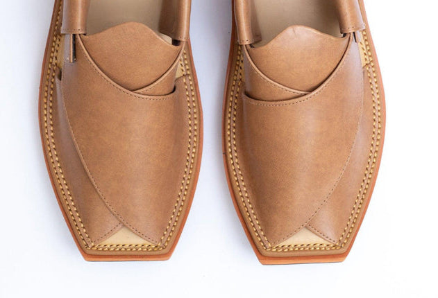 Pair of tan loafers on a white background