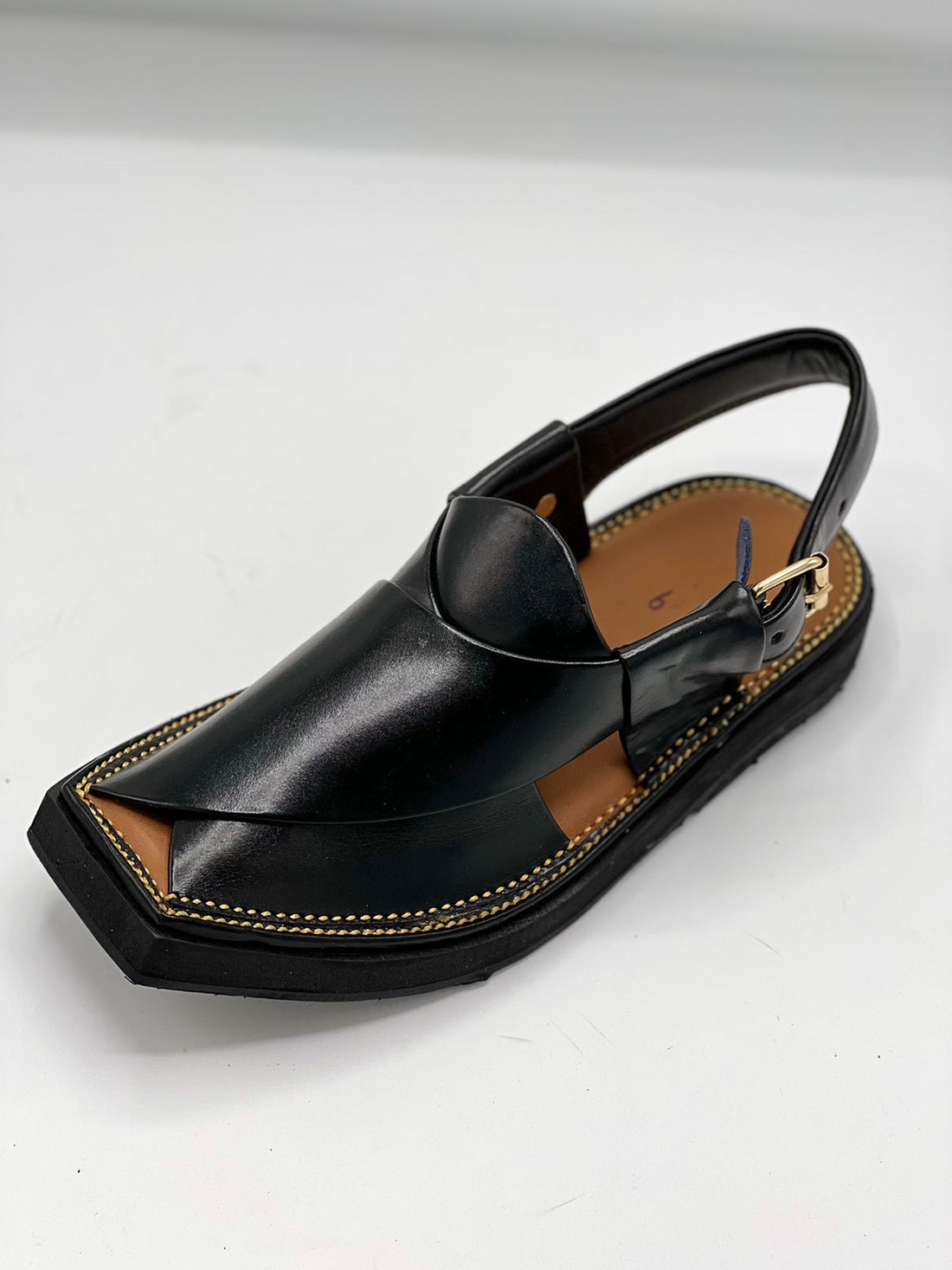 Black sandal with a unique design on a white background