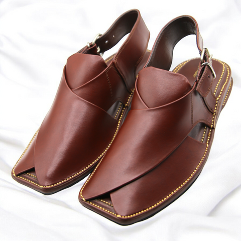 Brown leather shoes with gold stitching on a white background