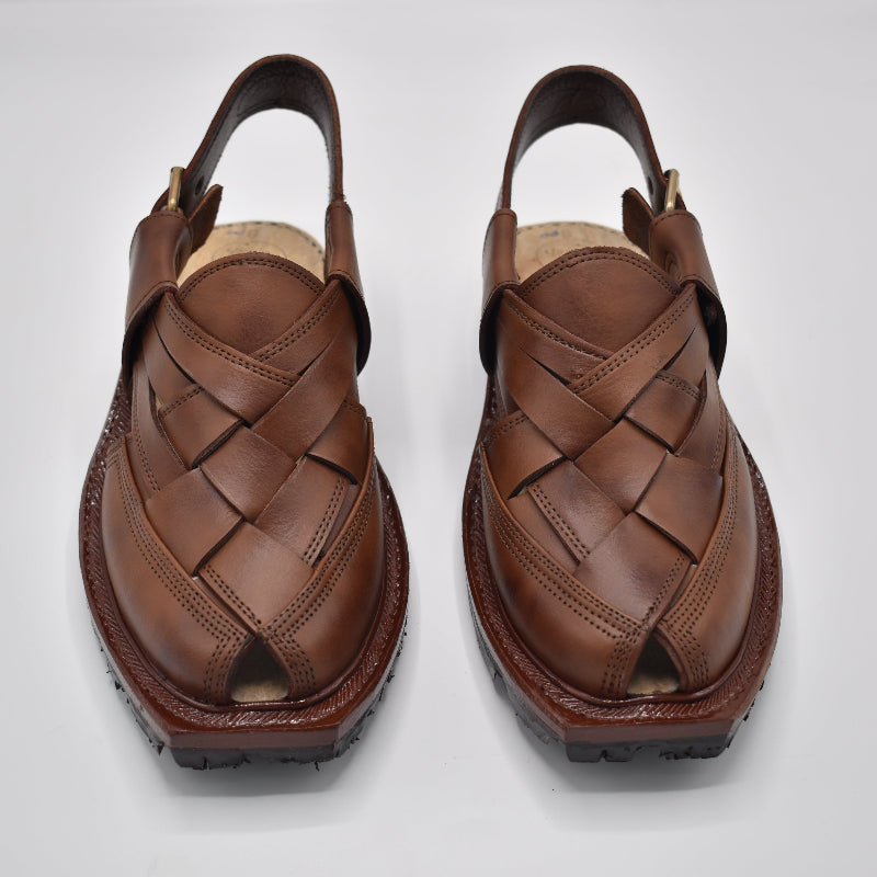 Pair of brown leather sandals with woven design on a white background