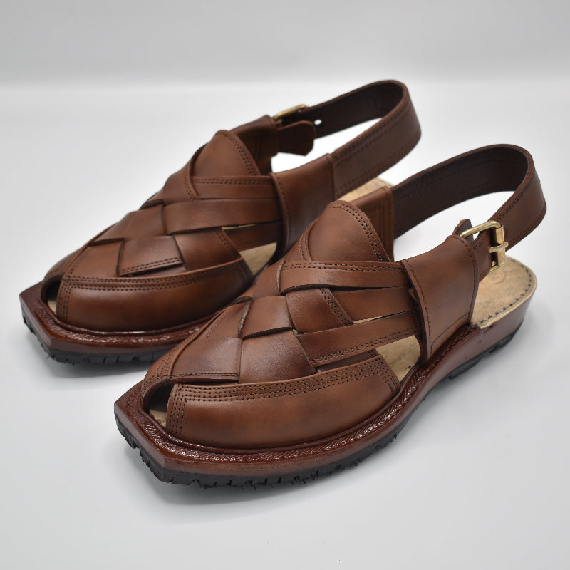 Pair of brown leather sandals on a light gray background