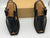 Pair of black shoes with brown accents on a white background